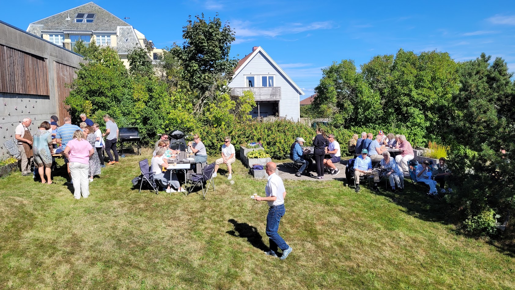 Bildet er fra fjorårets hagefest hvor mange mennesker koste seg i sola med god mat.